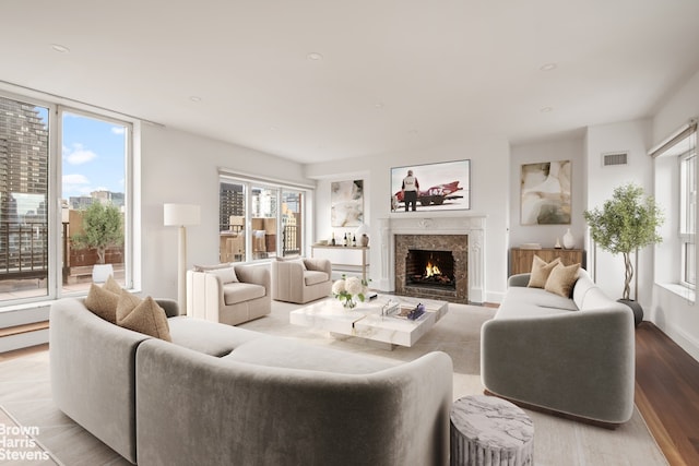 living room with light hardwood / wood-style floors and a premium fireplace