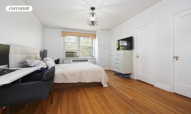 bedroom featuring light hardwood / wood-style flooring, radiator heating unit, cooling unit, and crown molding