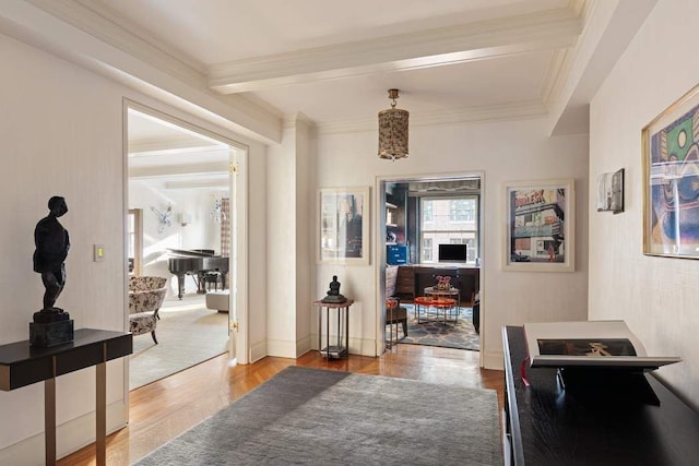 hallway with beamed ceiling, light wood-type flooring, and ornamental molding