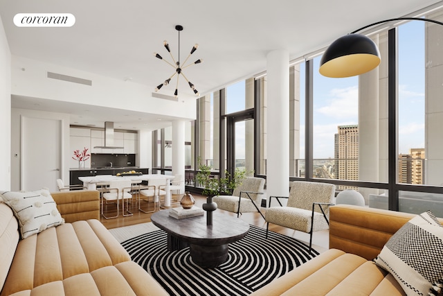 living room with sink, expansive windows, a chandelier, and light hardwood / wood-style floors