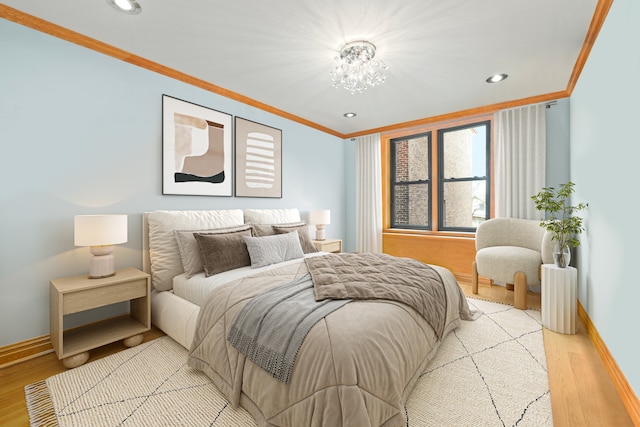 bedroom featuring ornamental molding, an inviting chandelier, and light hardwood / wood-style floors