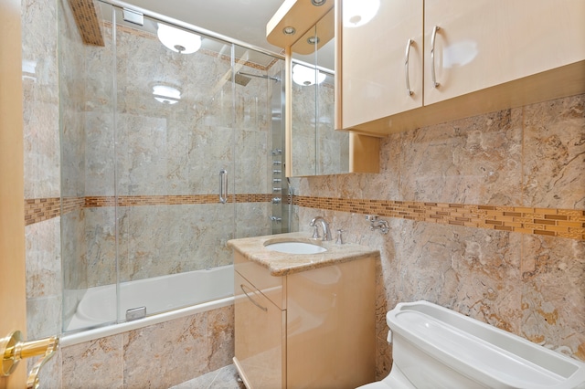 full bathroom with enclosed tub / shower combo, toilet, oversized vanity, and tile walls