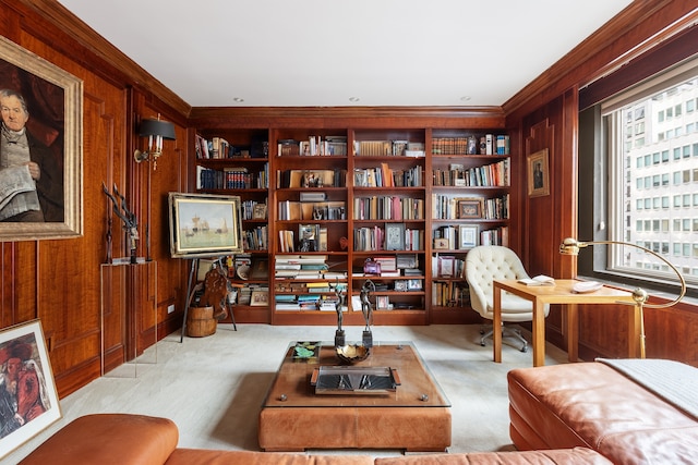 living area with crown molding, built in shelves, wood walls, and light colored carpet