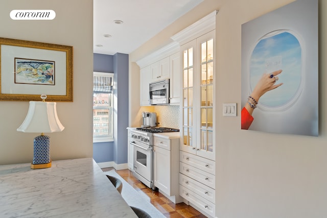 kitchen featuring white cabinets, appliances with stainless steel finishes, and decorative backsplash