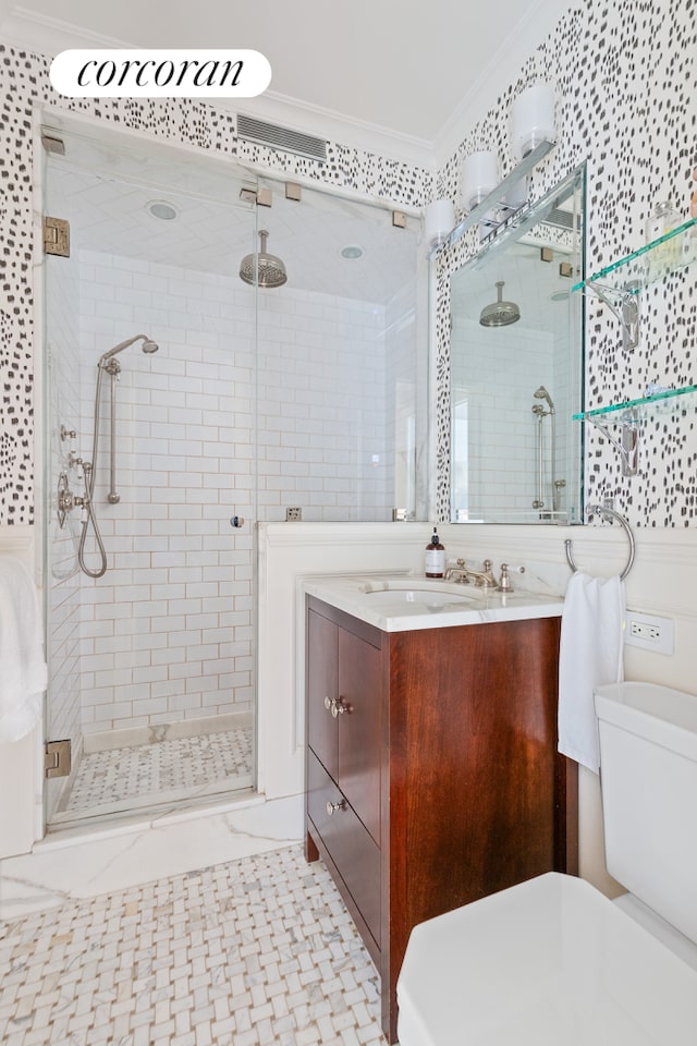 bathroom featuring a shower with door, vanity, toilet, and crown molding