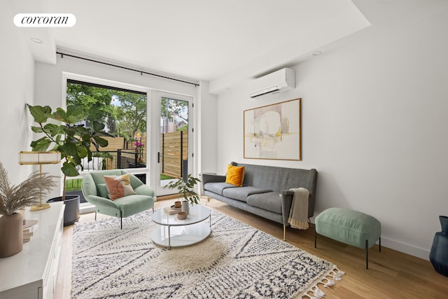 living room featuring a wall mounted air conditioner and hardwood / wood-style floors