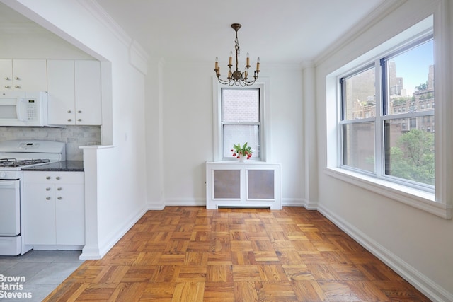 unfurnished dining area with ornamental molding, light parquet flooring, and a chandelier