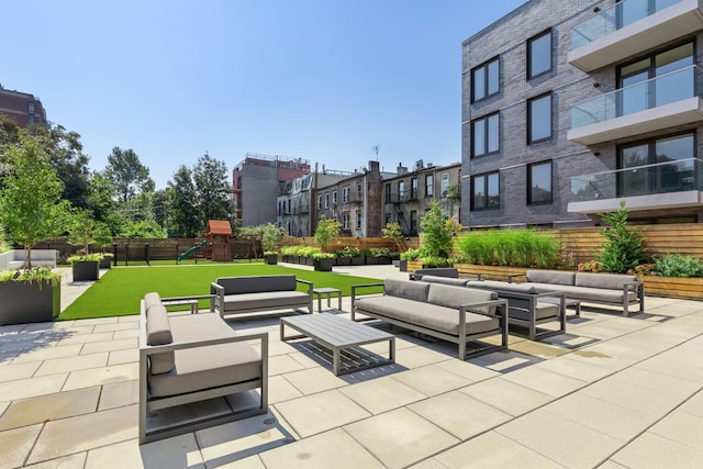 view of property's community featuring a playground, an outdoor hangout area, and a patio area