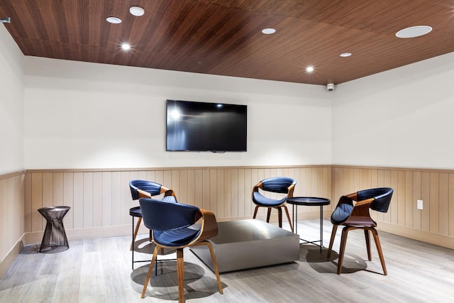 living area featuring wood ceiling, light wood-type flooring, and wooden walls