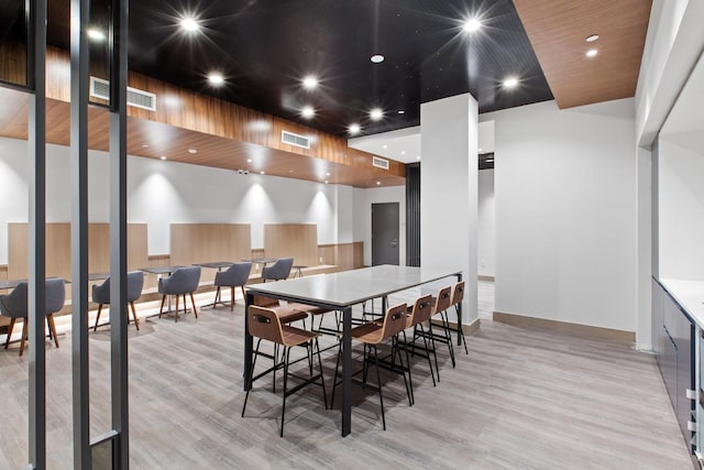 dining room with a high ceiling and light hardwood / wood-style floors