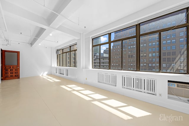 empty room featuring beamed ceiling and coffered ceiling