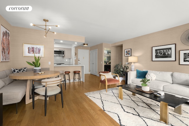 living room featuring a chandelier and light wood-type flooring