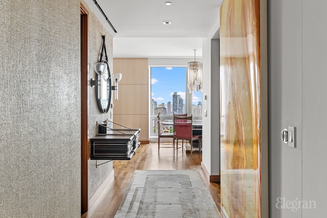 corridor with a chandelier and hardwood / wood-style floors