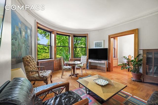 living room featuring crown molding and parquet flooring