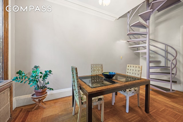 dining area featuring ornamental molding and parquet flooring