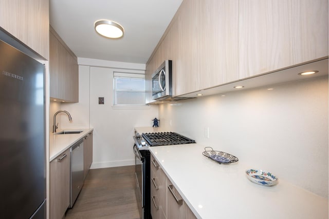 kitchen featuring dark hardwood / wood-style flooring, light brown cabinets, sink, and stainless steel appliances