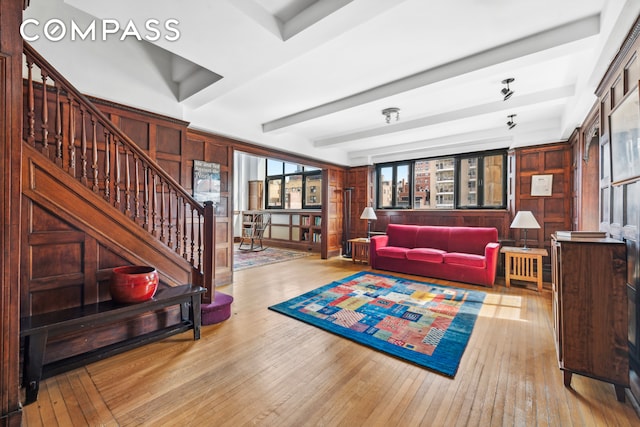 living room with beam ceiling and light wood-type flooring