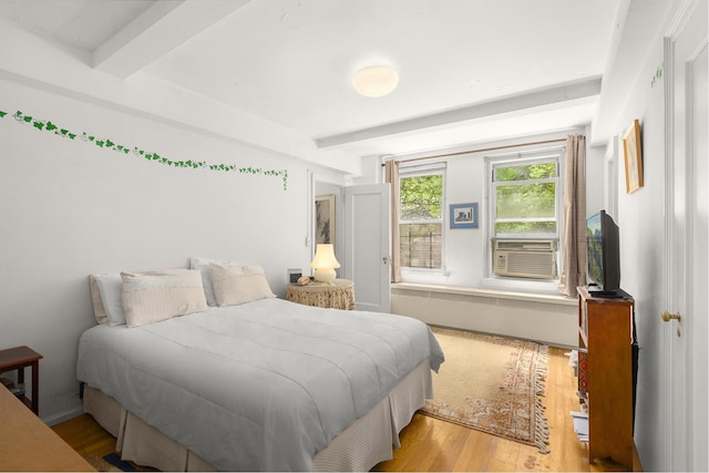 bedroom featuring beamed ceiling and wood-type flooring