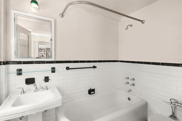 bathroom featuring tile walls, sink, and shower / bathtub combination