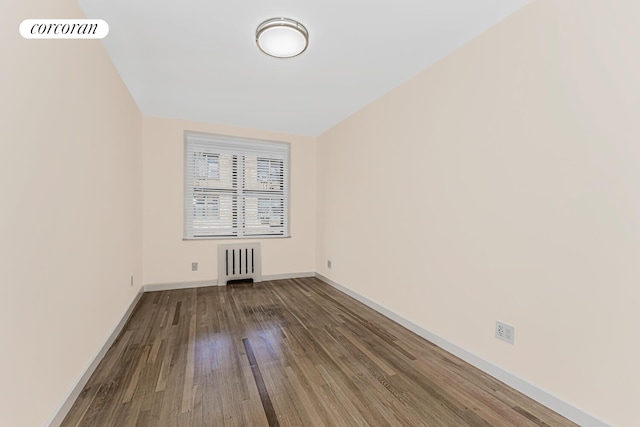 empty room featuring hardwood / wood-style flooring and radiator