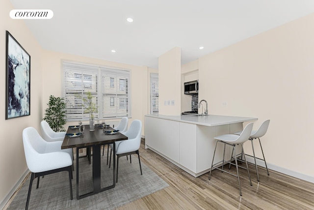 dining room with sink and light wood-type flooring