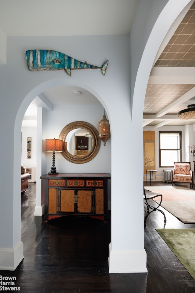 interior space featuring beam ceiling, radiator heating unit, and dark wood-type flooring