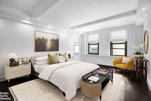 bedroom with beamed ceiling and hardwood / wood-style flooring