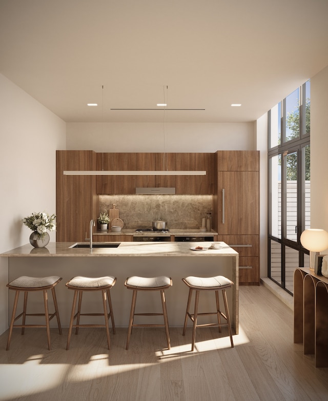 bar with floor to ceiling windows, backsplash, sink, light hardwood / wood-style floors, and stovetop