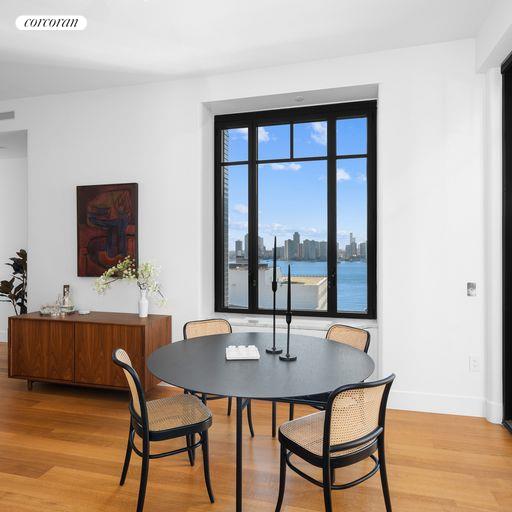 dining area with a water view and light hardwood / wood-style flooring