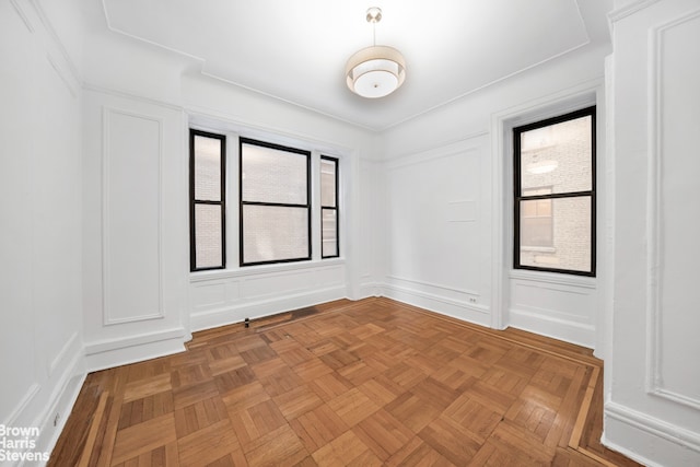 spare room featuring parquet flooring and a wealth of natural light