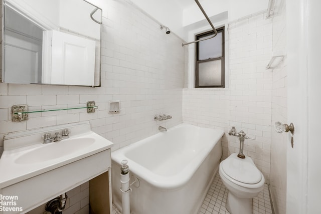 bathroom featuring sink, toilet, tile patterned flooring, and tile walls