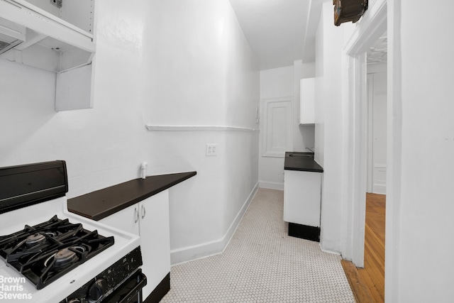 kitchen featuring gas range gas stove, light hardwood / wood-style flooring, and white cabinets