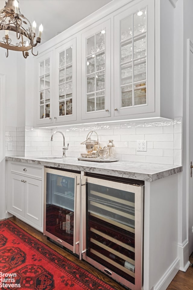 bar with backsplash, wine cooler, white cabinets, and dark hardwood / wood-style floors