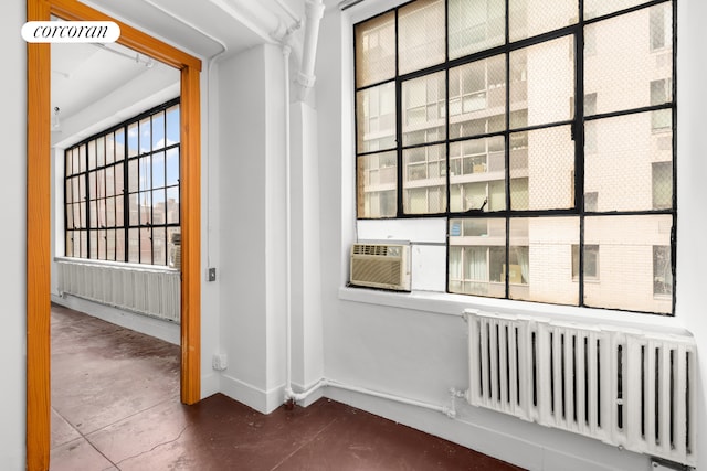 interior space with cooling unit, concrete flooring, and radiator