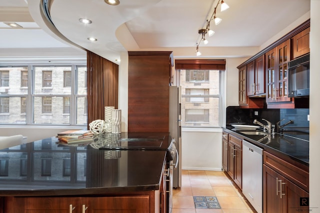 kitchen with light tile patterned flooring, high quality range, dishwasher, decorative backsplash, and sink