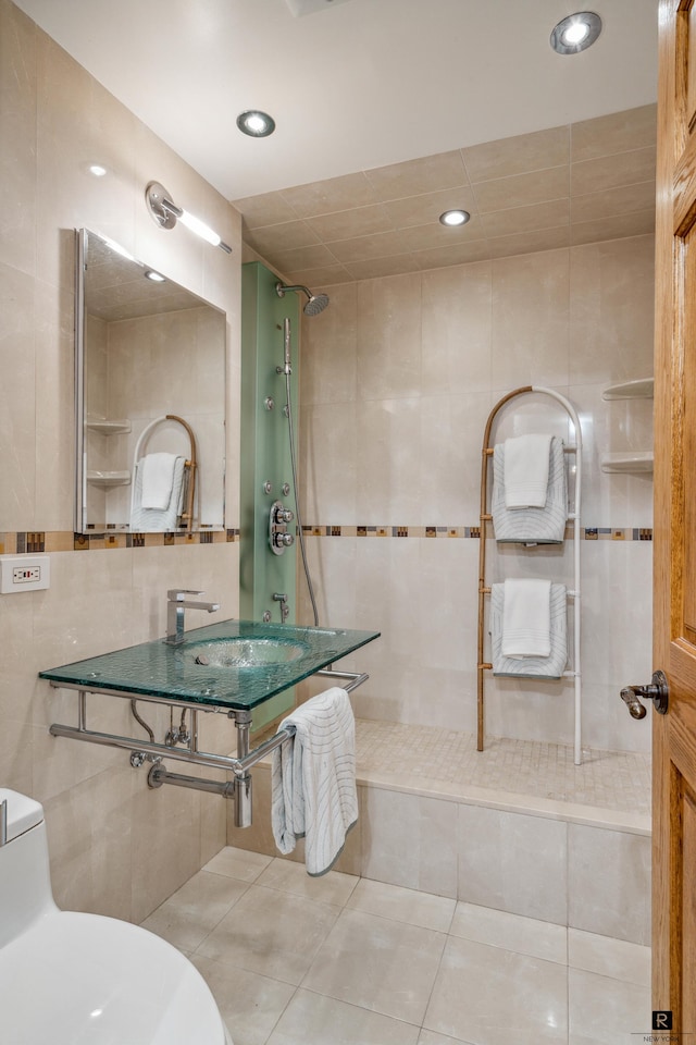 bathroom with vanity, a tile shower, tile patterned floors, and tile walls