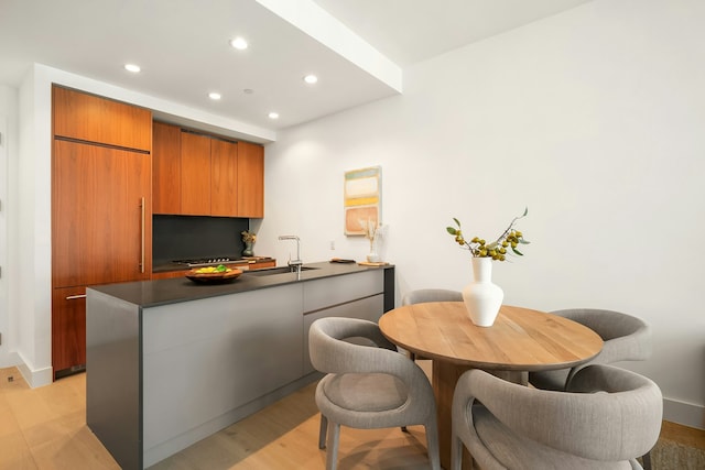 kitchen with paneled fridge, light hardwood / wood-style floors, sink, and kitchen peninsula