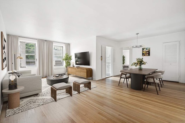 living room featuring light wood-type flooring and a chandelier