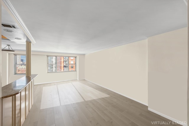 unfurnished room featuring wood-type flooring, crown molding, and decorative columns