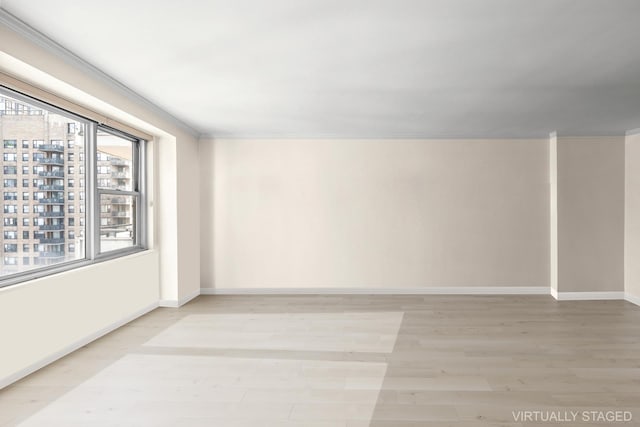 empty room with light wood-type flooring and crown molding