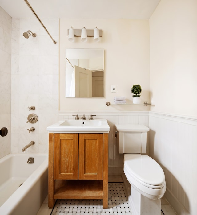 full bathroom featuring tile patterned floors, tiled shower / bath combo, toilet, and vanity