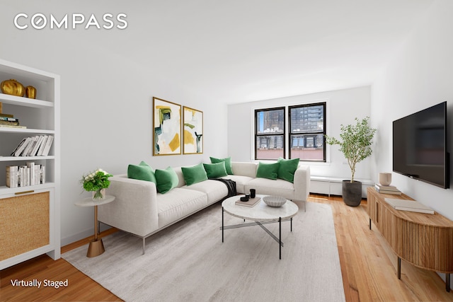 living room featuring built in shelves and hardwood / wood-style floors