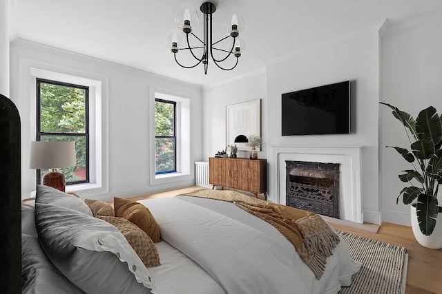 bedroom with multiple windows, light wood-type flooring, and ornamental molding