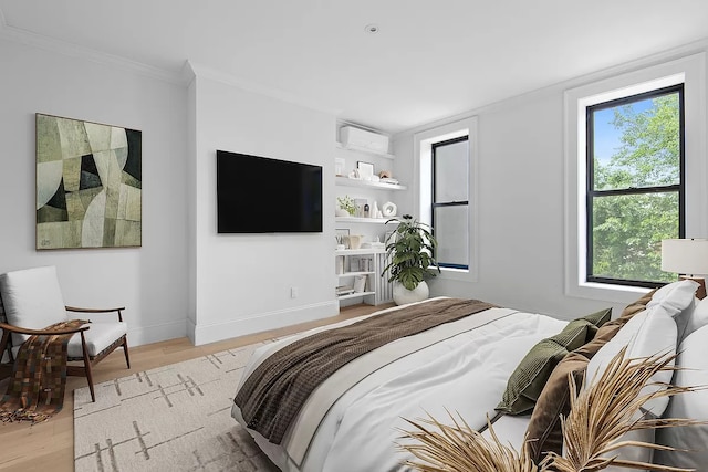 bedroom featuring ornamental molding, multiple windows, a wall unit AC, and light wood-type flooring