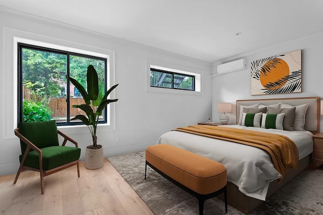 bedroom with an AC wall unit, wood-type flooring, and crown molding