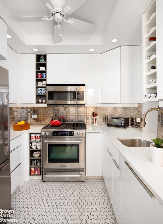 kitchen featuring white cabinets, stainless steel appliances, tasteful backsplash, and sink