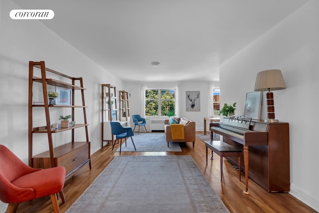 living area with hardwood / wood-style flooring and radiator