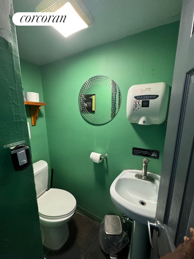 bathroom with sink, toilet, and tile patterned flooring