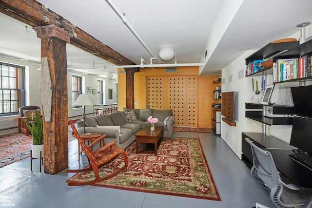 living room featuring beam ceiling and ornate columns