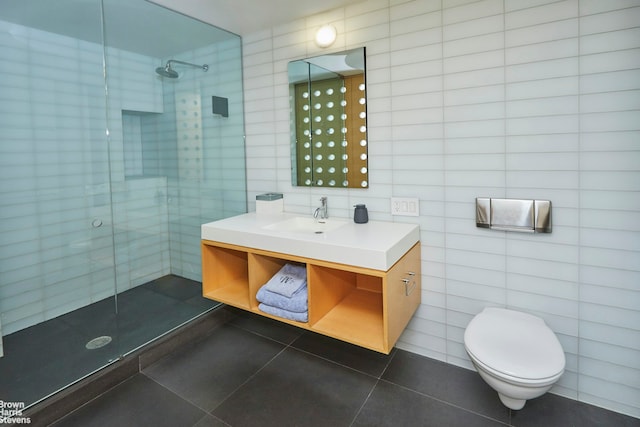 bathroom featuring a tile shower, tile patterned flooring, and tile walls